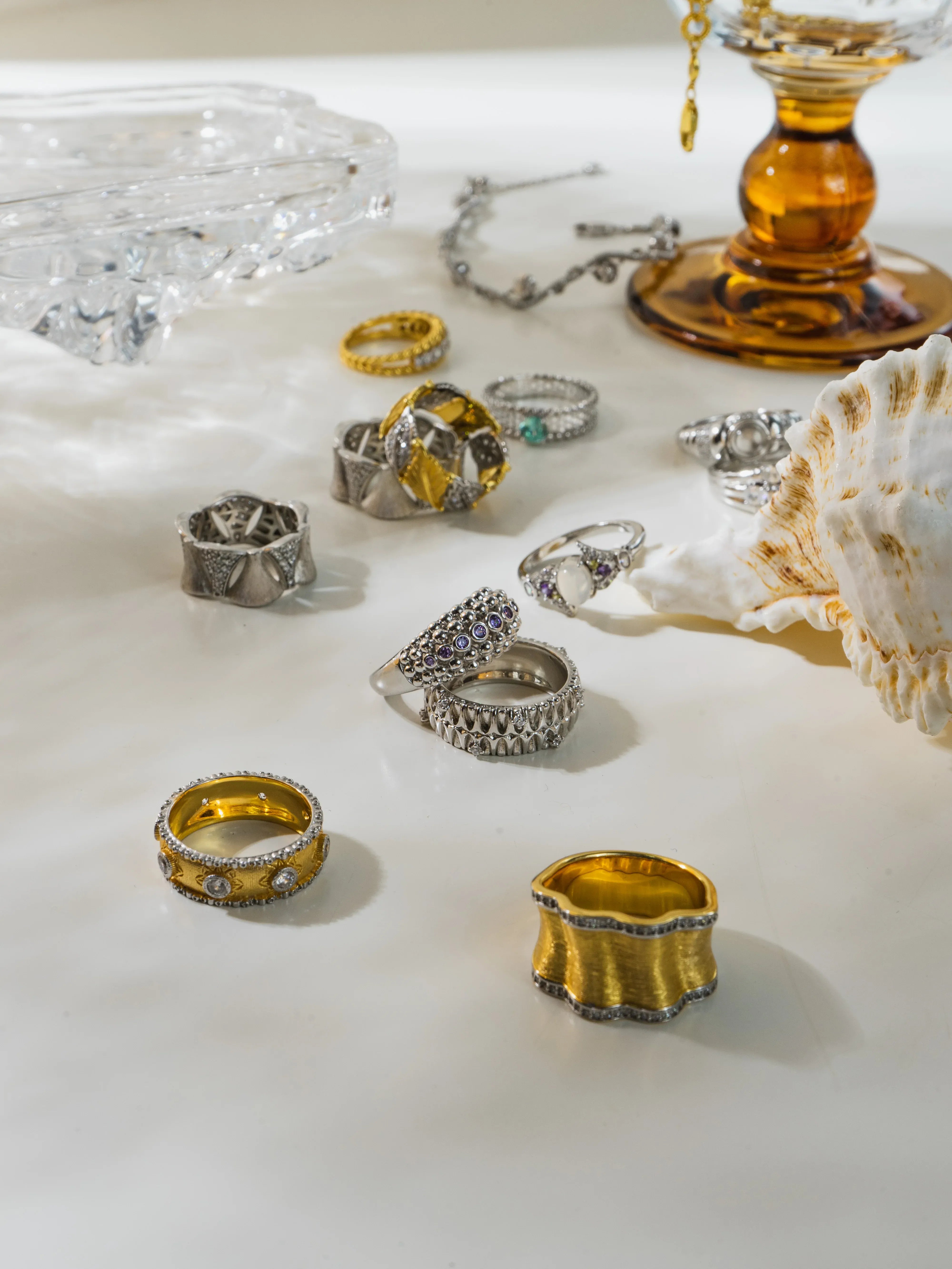 Collection of various rings on a textured surface with decorative elements.
